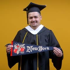 Anthony Fernandez, SNHU graduate with a bachelor's in political science, holding a New York state flag.