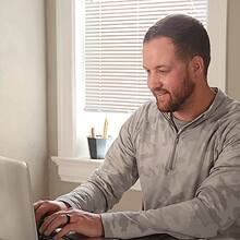 Wyatt Martensen sitting at a desk working on a laptop