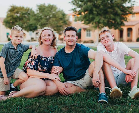 Bonnie Conrad sitting to the left of her husband. There are two sons, one on either side of the couple.