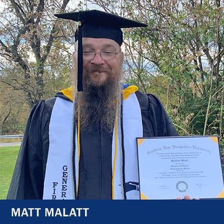 Matt Malatt, 2021 SNHU Graduate, standing in his cap and gown and holding his diploma