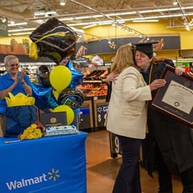 Carol D'Anna hugging Lisa Marsh Reyerson after being awarded her diploma