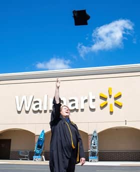 Carol D'Anna throwing her cap in the air in front of Walmart