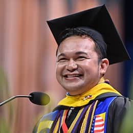 Jerry Demecillo Tambiling, a 2026 SNHU graduate with a bachelor's in business administration, speaking at his commencement ceremony.