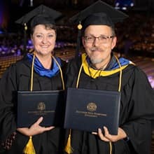 Kathleen Greenwood, left, and Jason Greenwood, right, dressed in their SNHU graduation attire.