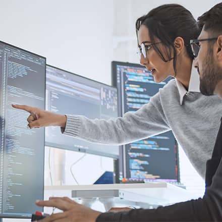 Two computer science professionals using their skills at work.