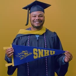 Cules Rose '25, bachelor's in finance graduate from SNHU holding an SNHU pennant.