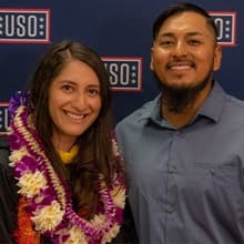 Diana Tafoya Sanchez with her gown on and an Hawaiian lei standing with Jose Castro