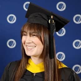 Emily Bevens, a 2023 SNHU graduate with a master’s degree in forensic psychology, dressed in a graduation cap and gown.