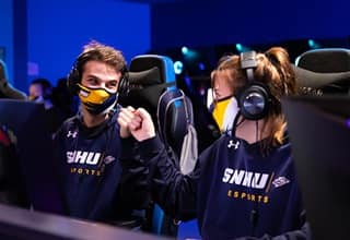 Two SNHU esports players fist bumping