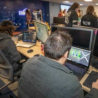 Group of SNHU students in SNHU’s Inkwell Interactive Game Studio coding a video game