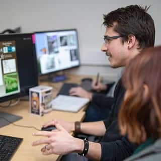 SNHU student coding a video game on his computer