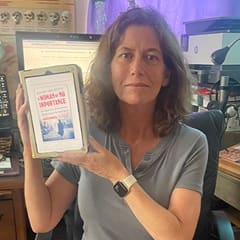 Heather York, a social science adjunct instructor at SNHU, holding "A Woman of No Importance: The Untold Story of the American Spy Who Helped Win World War II" by Sonia Purnell.