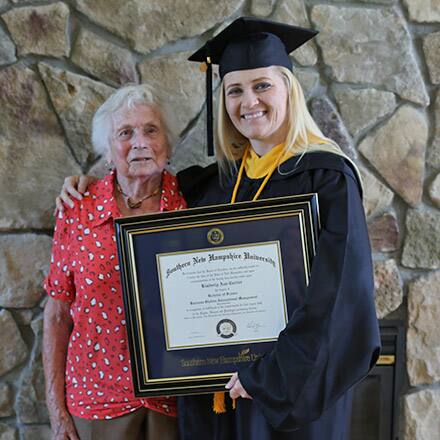 Kimberly Cartier wearing a cap and gown 