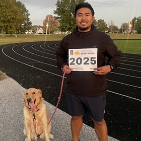 SNHU community member taking part in the virtual fun run/walk with a dog.