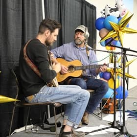 Musicians playing guitar at the Homecoming country-fair dinner.