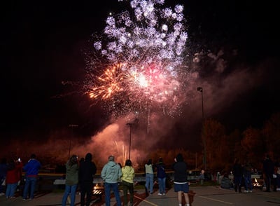 People watching fireworks on Southern New Hampshire University's campus in celebration of 2023 Homecoming
