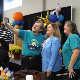 President Lisa Marsh Ryerson taking a selfie with two Homecoming brunch attendees.