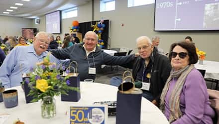 Four New Hampshire College alumni enjoying brunch and visiting with old classmates.