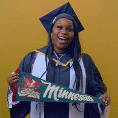Jazzmen Shipp, a 2025 SNHU graduate who earned an associate degree in business administration holding a Minnesota state flag.
