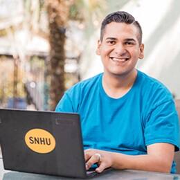 Juan Munoz '22 '24MBA, bachelor's in general studies and Master of Business Administration (MBA) from SNHU working on his laptop.