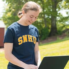 SNHU student Kayla Stoll studying online while outdoors.