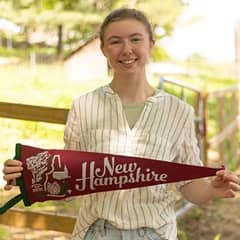 SNHU student Kayla Stoll holding a New Hampshire state pennant.