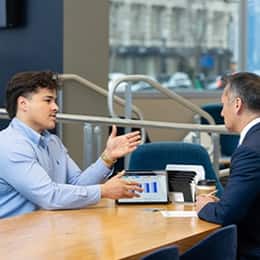 Kevin Bucardo '25MBA, MBA with a concentration in Finance graduate from SNHU, having a business conversation at work.