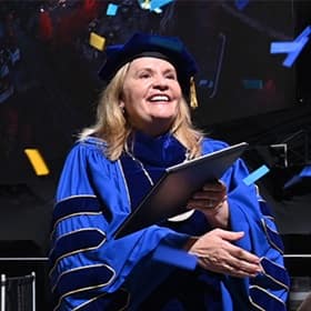 President Lisa Marsh Ryerson holding a diploma at the SNHU 2025 Fall Commencement.