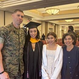 Lorna Perez, second from left, dressed in a cap and gown, standing with three family members at MCB Quantico graduation ceremony.