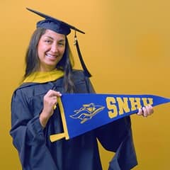Luciana Henderson, a 2025 SNHU graduate who earned a master of science in nursing with a concentration in nursing education, holding an SNHU flag.