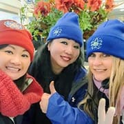 Three female volunteers wearing hats at the Macy's Day Parade.
