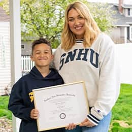 Madison Richards '26 and her son holding her diploma.