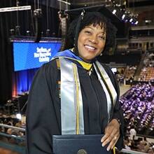 Marilynn Hymon-Williams dressed in a graduation cap and gown