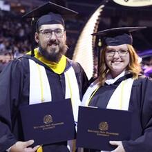 Michael and Taria Richards holding their diplomas at the SNHU graduation