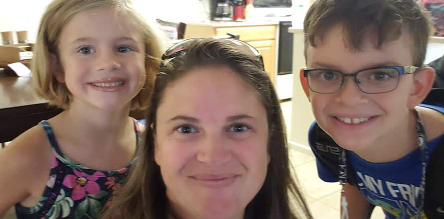 A selfie of Heather Poss and two of her children in their kitchen