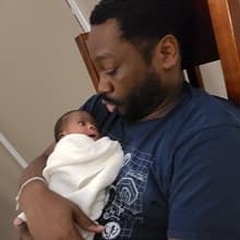 Steven Moore holding his newborn baby.