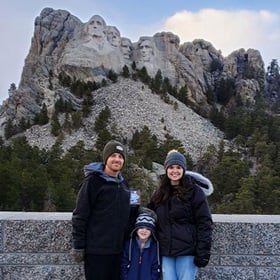 Tara Yonce with her husband and son in front of Mount Rushmore