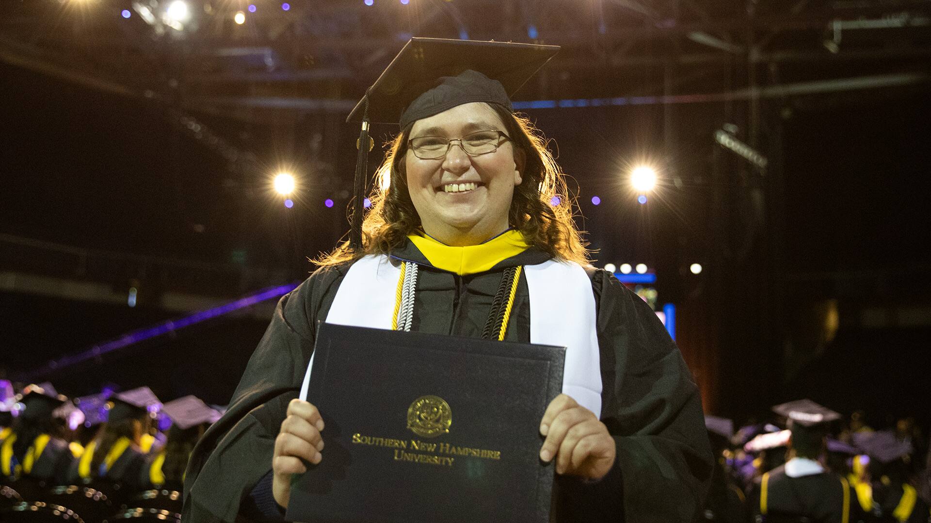 Karie Lamb, holding her online business degree diploma at SNHU's 2023 commencement ceremony.