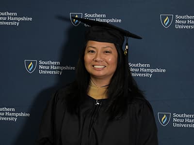 Edelyne Castillo, who earned her online MBA from SNHU in 2023, wearing her graduation cap and gown.
