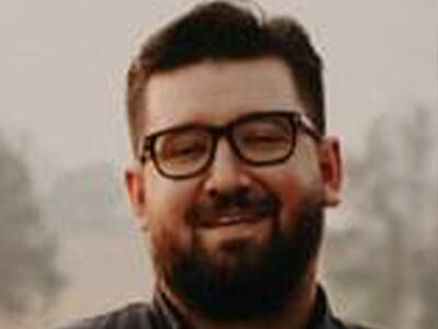 Ethan Gutierrez, who earned his online MBA with a concentration in Accounting in 2021, with eyeglasses and a brown beard.