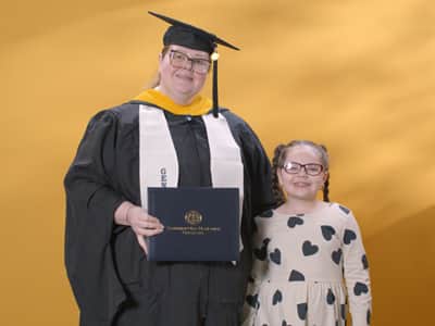 Jessica Yonice Vazquez, a 2024 graduate who earned her master’s in human resource management at SNHU standing with her daughter.