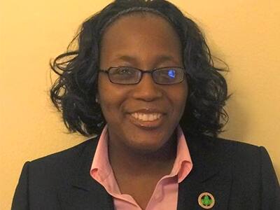Dr. Tharinia Oyegun, an associate dean of criminal justice at SNHU, wearing a black blazer and white shirt.
