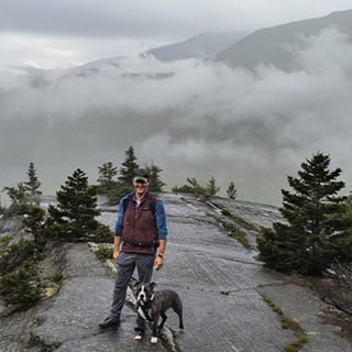 Ben Cole and his dog hiking on a mountain