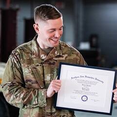 U.S. service member and SNHU graduate Rob Thomas holding his diploma.