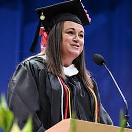 Shannon Michelle Hons, a 2026 SNHU graduate with a bachelor's in creative writing and English, speaking at her commencement ceremony.