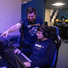 Two SNHU students working together in the Esports arena.