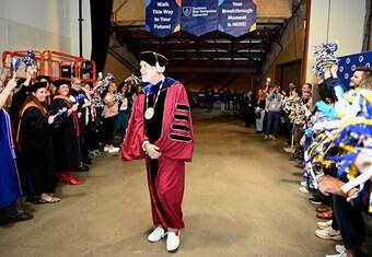 SNHU President Dr. Paul J. Leblanc walking out of the SNHU 2024 Commencement surrounding by SNHU faculty and staff