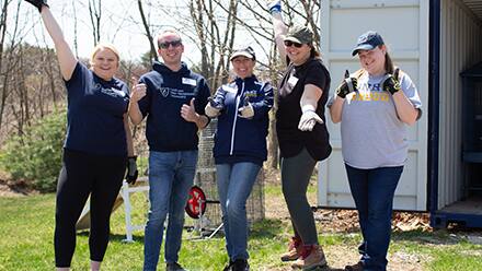 A group of SNHU volunteers outdoors at a community service event.