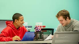 Two students working together at a desk