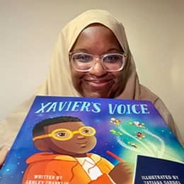 Ashley Franklin, an adjunct instructor at SNHU holding her book 'Xavier’s Voice.'